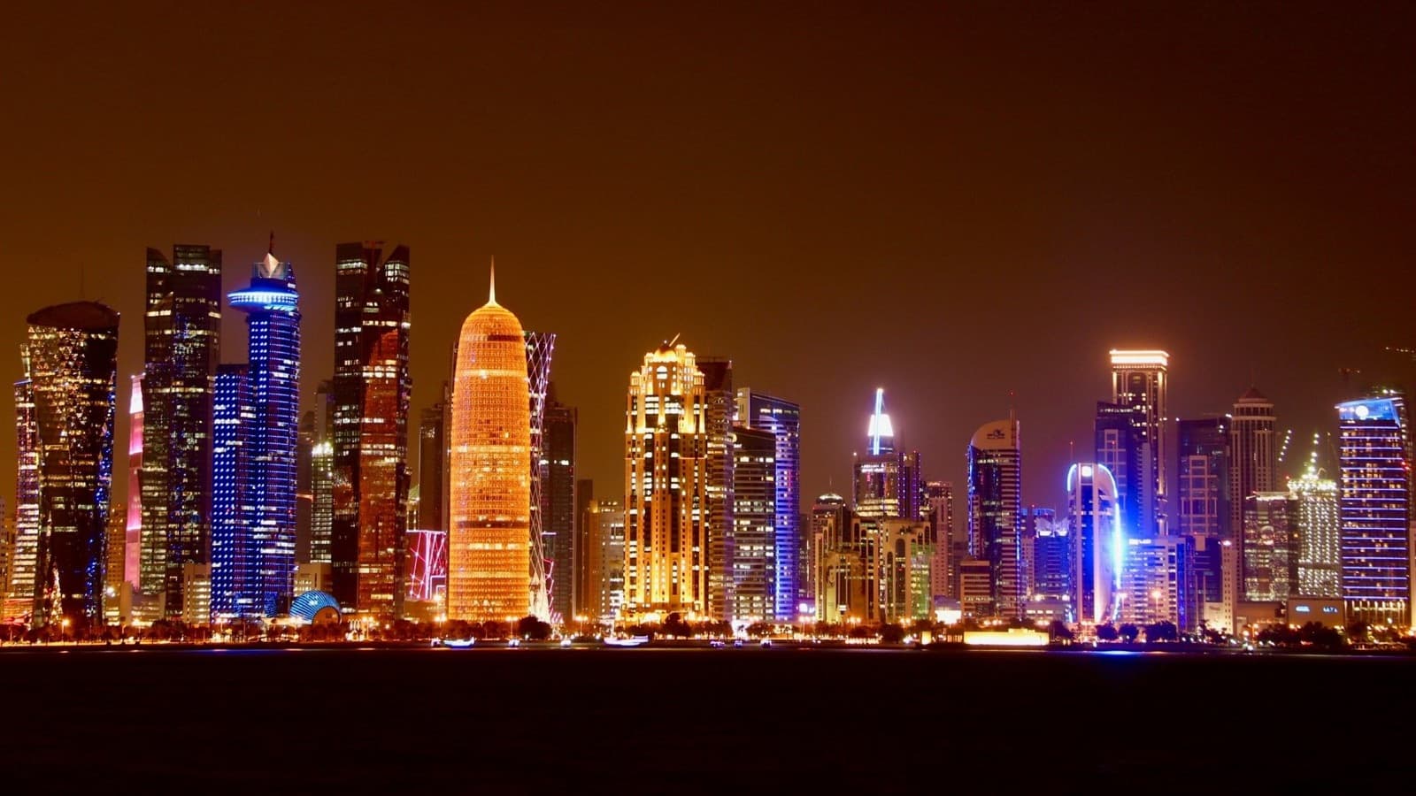 Doha's skyline lit at night, seen across the bay